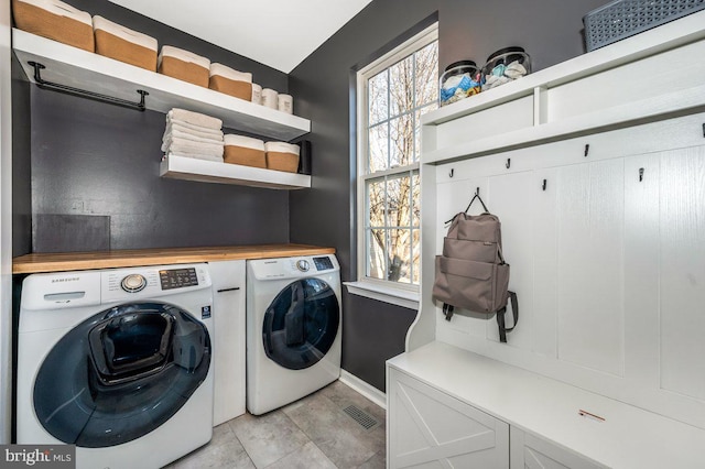 washroom with laundry area, baseboards, visible vents, and independent washer and dryer