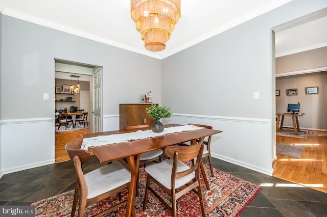 dining space with stone tile flooring, baseboards, a chandelier, and crown molding