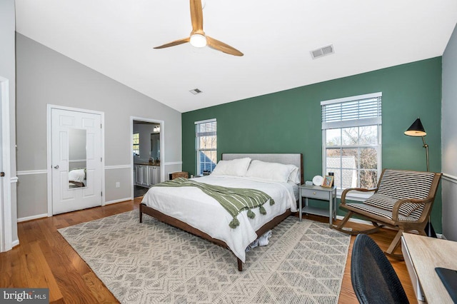 bedroom featuring wood finished floors, visible vents, and multiple windows