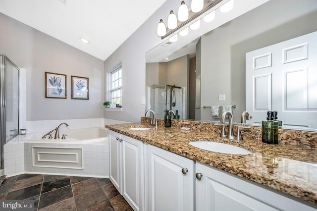 bathroom featuring lofted ceiling, a sink, a bath, and a shower stall