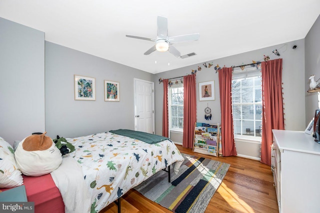 bedroom featuring light wood-style floors, ceiling fan, and visible vents