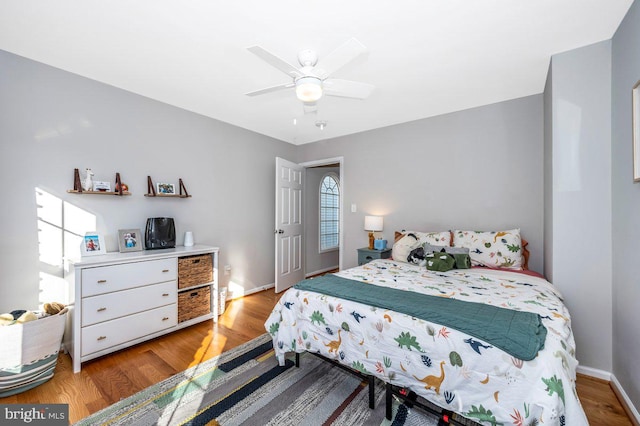 bedroom with baseboards, ceiling fan, and light wood finished floors