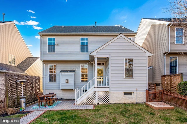 rear view of house featuring a lawn, a patio area, and a fenced backyard