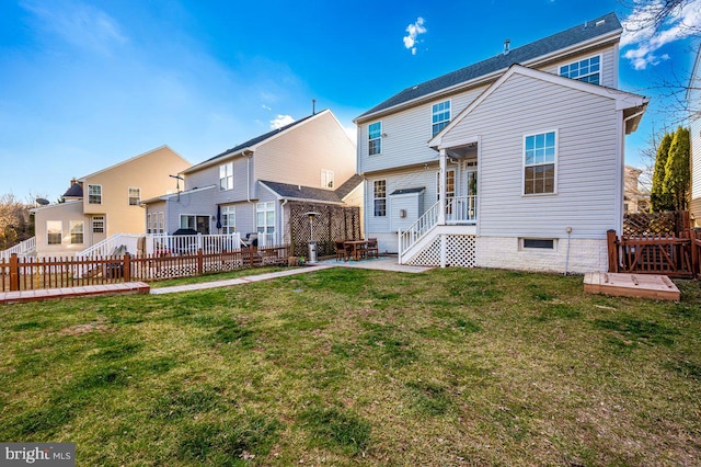 rear view of property with a residential view, a patio area, a fenced backyard, and a yard