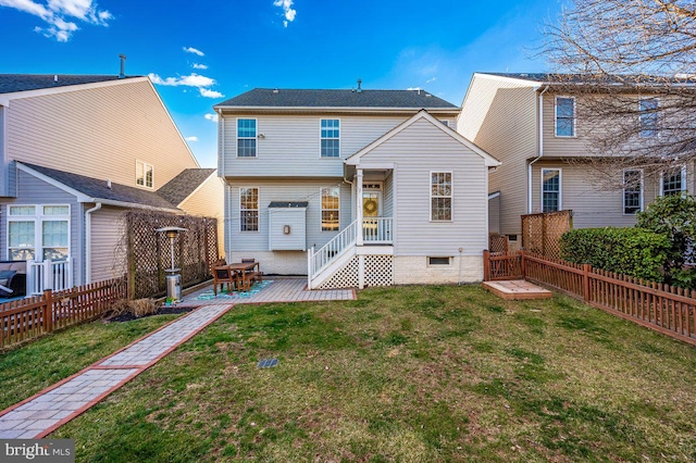 rear view of property featuring a fenced backyard and a yard