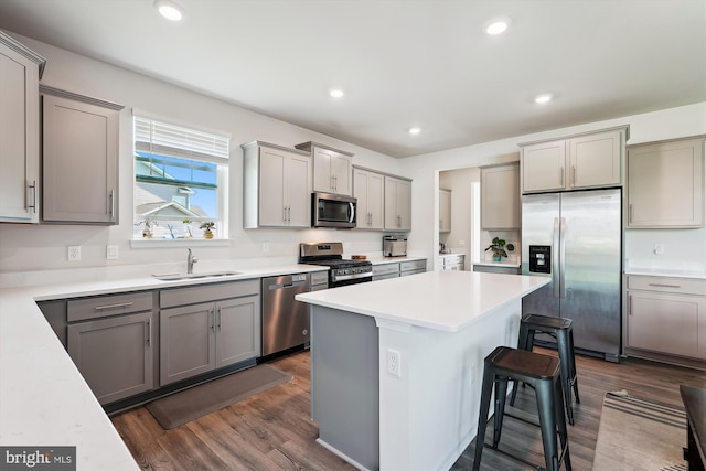 348 Tyson Dr, Berryville, VA 22611 - kitchen with appliances with stainless steel finishes, a sink, gray cabinetry, a breakfast bar, and a kitchen island