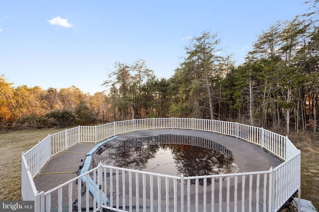 view of swimming pool featuring a view of trees