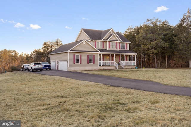 view of front facade featuring aphalt driveway, a front yard, and covered porch