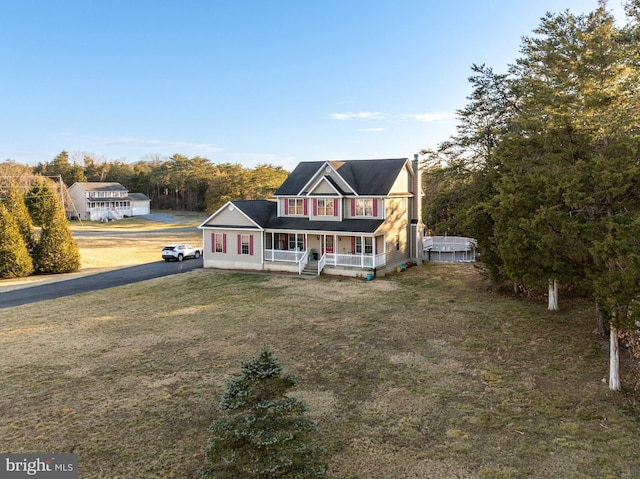 view of front of home with covered porch and a front lawn