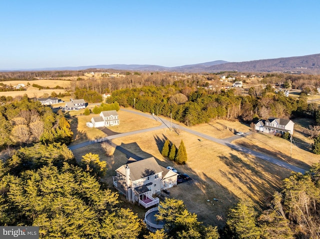 drone / aerial view featuring a mountain view and a view of trees