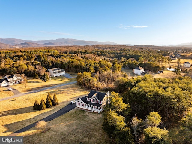 drone / aerial view with a wooded view and a mountain view