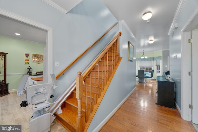 staircase featuring ornamental molding, baseboards, and wood finished floors