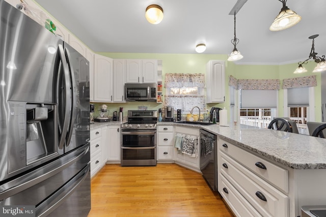 kitchen with stainless steel appliances, a peninsula, a sink, white cabinets, and light wood-type flooring