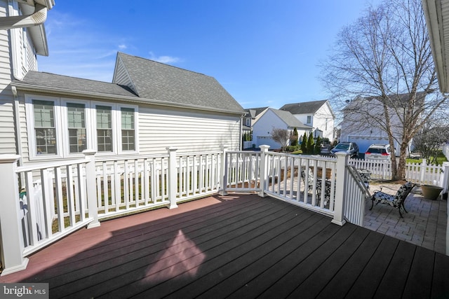 deck featuring a patio area, fence, and a residential view