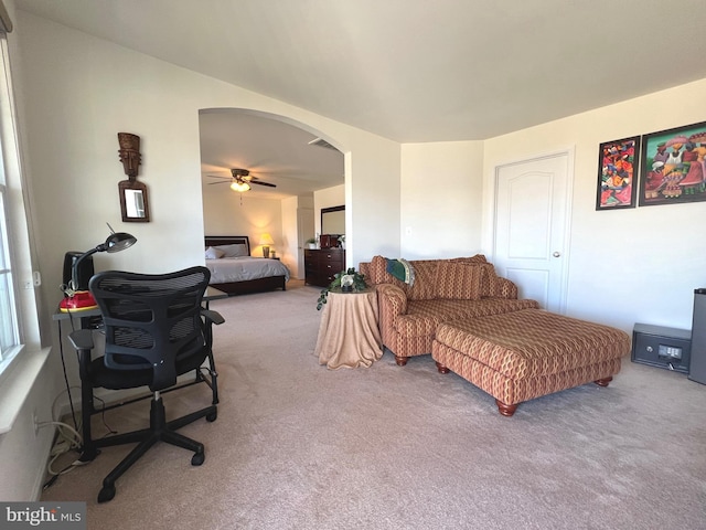 bedroom with a ceiling fan, visible vents, light colored carpet, and arched walkways