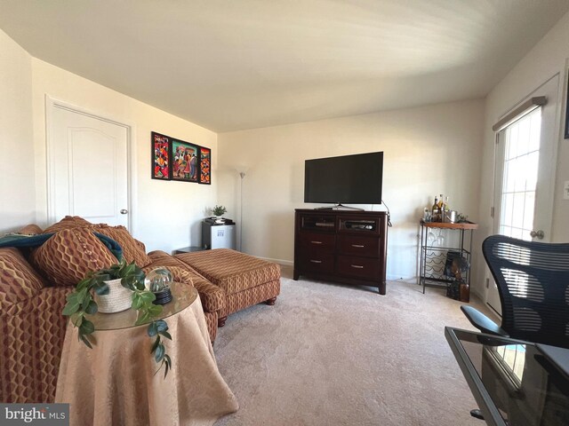 living area with baseboards and light carpet