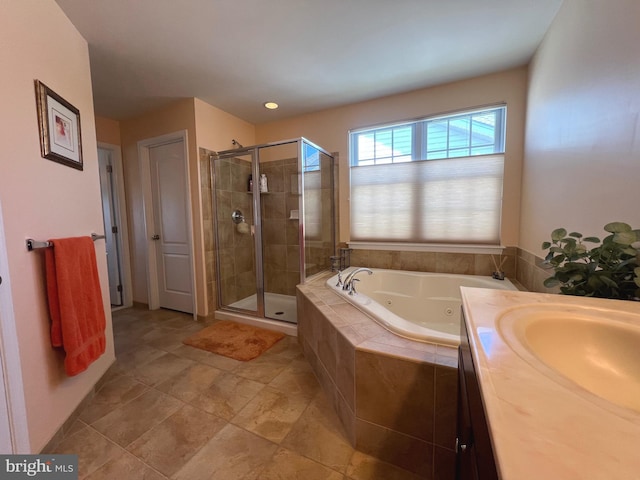 full bathroom with a tub with jets, a shower stall, and a sink