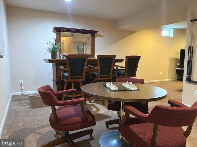 carpeted dining area featuring baseboards