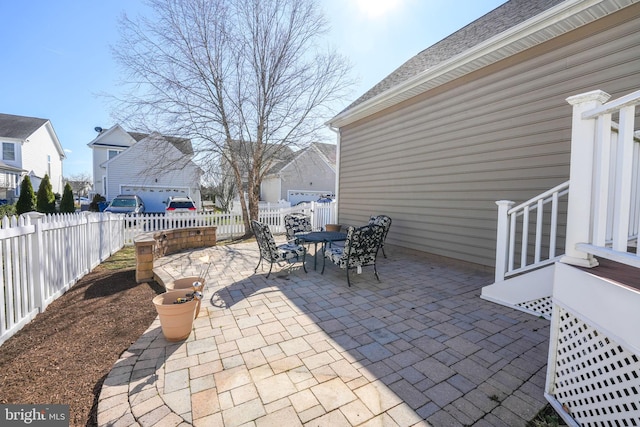 view of patio / terrace featuring a fenced backyard, a residential view, and outdoor dining space