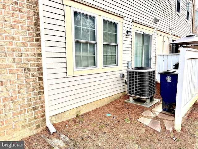 exterior space with central AC and brick siding