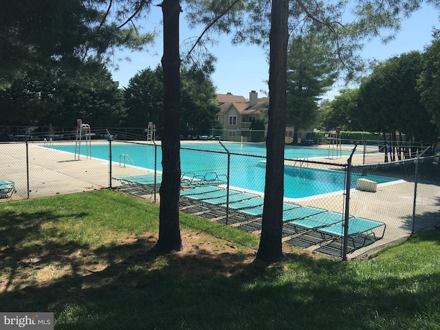 pool featuring a lawn and fence