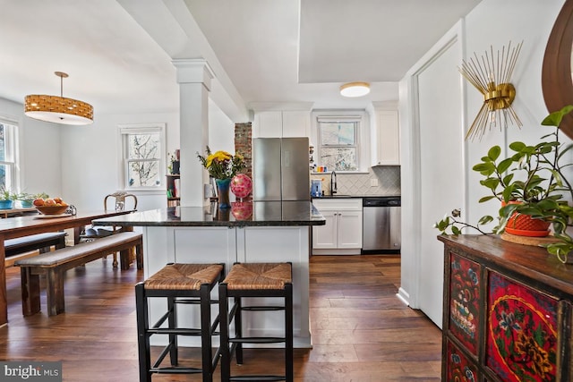 kitchen featuring a wealth of natural light, ornate columns, and stainless steel appliances