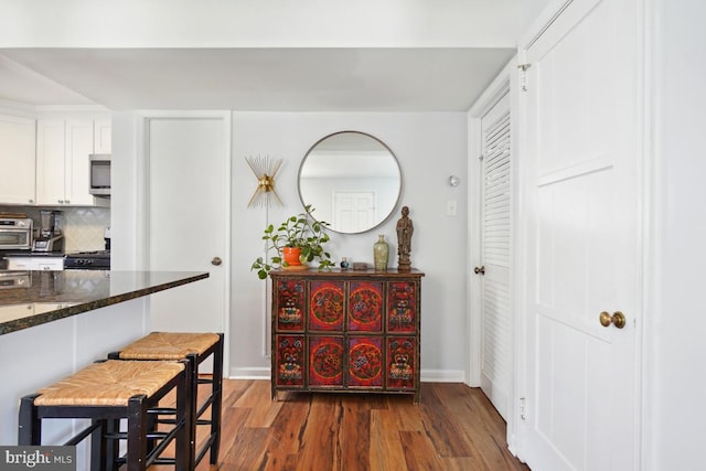 dining room with dark wood-type flooring and baseboards