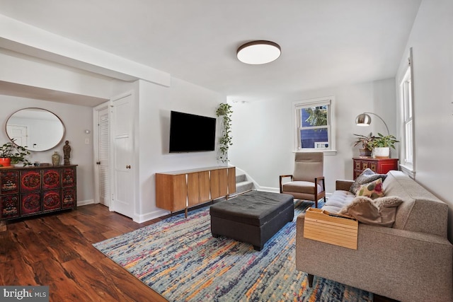 living room featuring stairway, baseboards, and wood finished floors