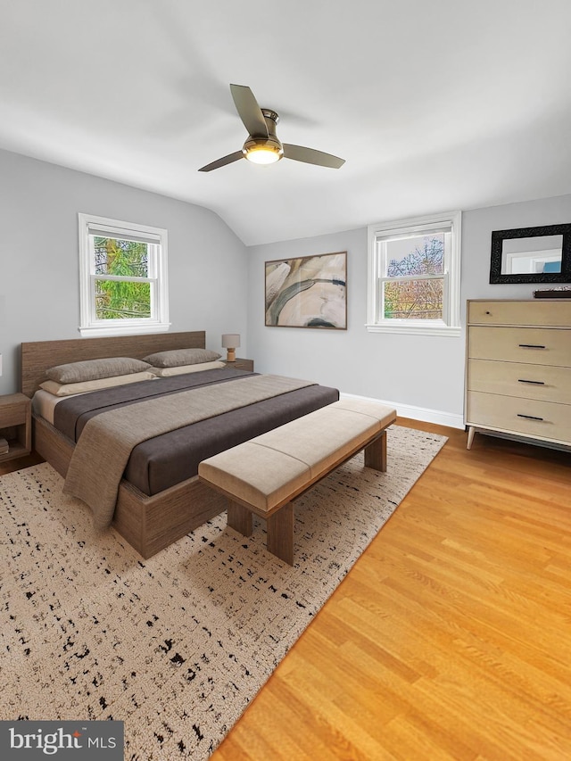 bedroom with lofted ceiling, wood finished floors, baseboards, and ceiling fan