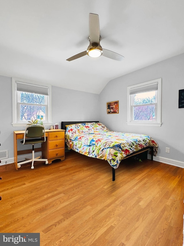 bedroom featuring visible vents, ceiling fan, baseboards, light wood-type flooring, and lofted ceiling