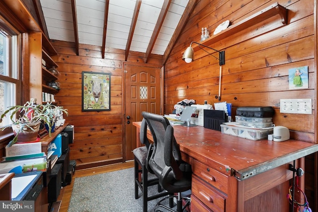 office featuring wood walls, vaulted ceiling with beams, and light wood-type flooring