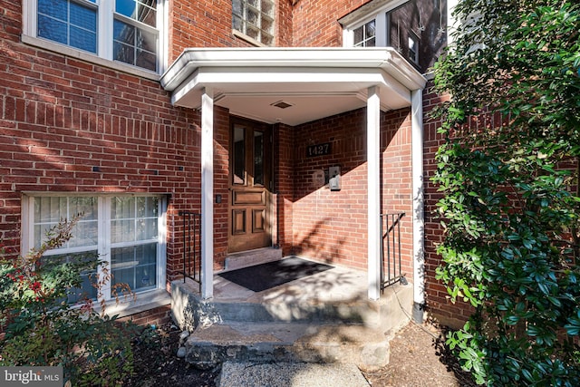 view of exterior entry with brick siding