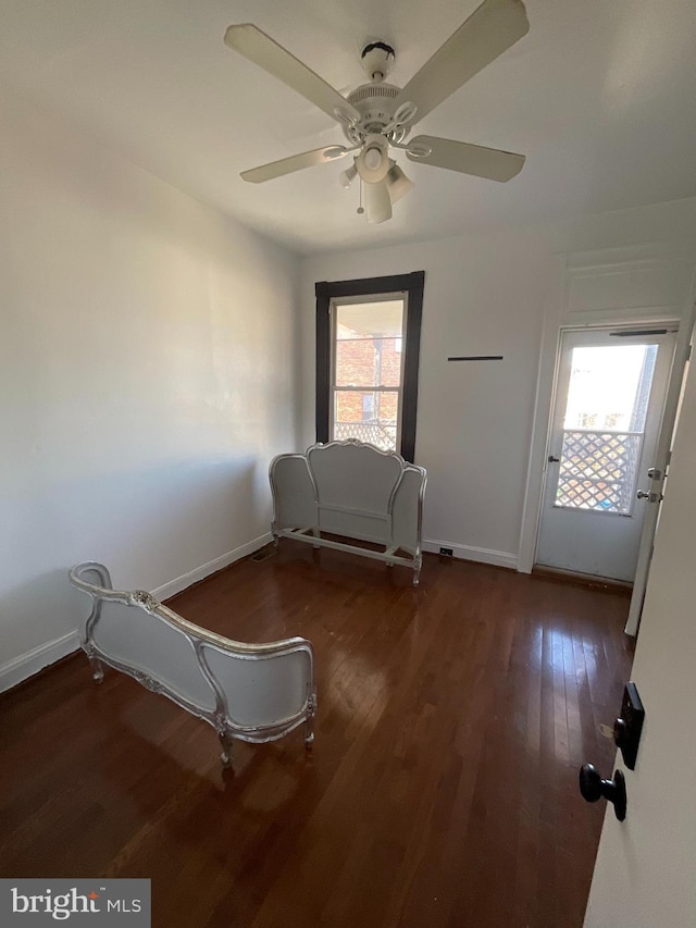 unfurnished room featuring dark wood-type flooring, plenty of natural light, and baseboards