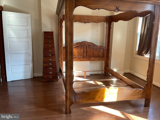 unfurnished bedroom featuring dark wood finished floors and baseboards