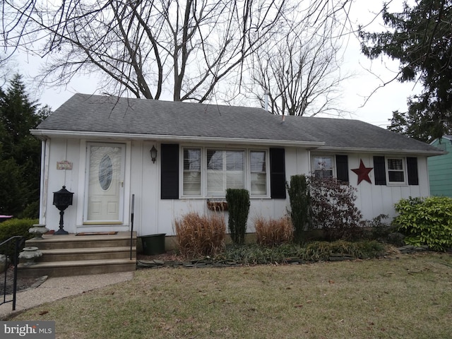 view of front of property featuring a shingled roof, board and batten siding, and a front yard