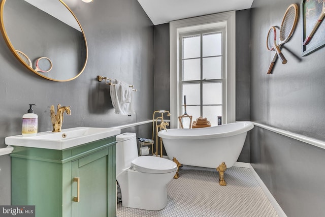 bathroom with toilet, a soaking tub, tile patterned flooring, and vanity