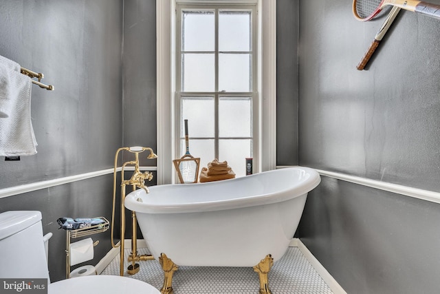 bathroom with toilet and a soaking tub