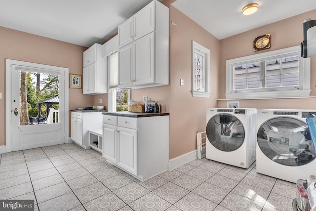 washroom with separate washer and dryer, light tile patterned flooring, cabinet space, and baseboards