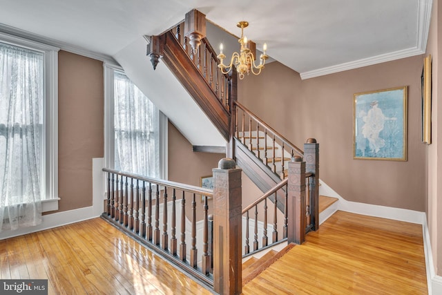 stairway with a chandelier, ornamental molding, wood-type flooring, and baseboards