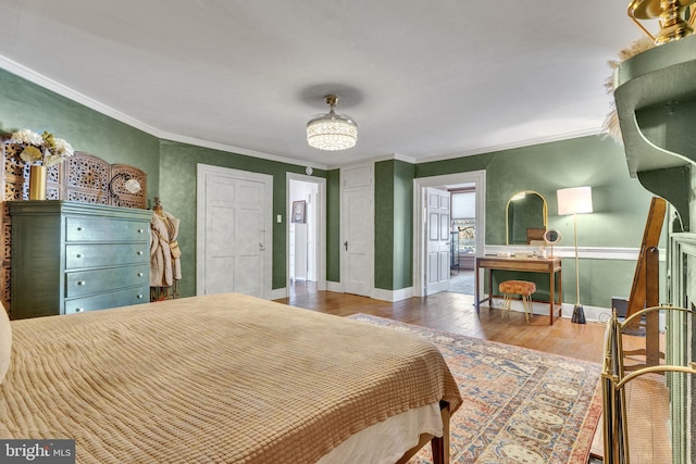 bedroom featuring baseboards, ornamental molding, and wood finished floors