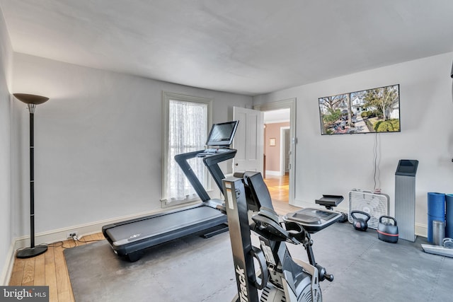 exercise area featuring baseboards and wood finished floors