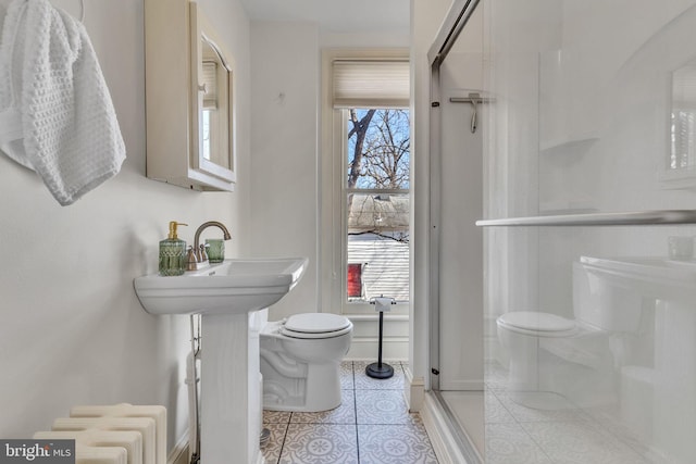 bathroom with a stall shower, tile patterned flooring, and toilet