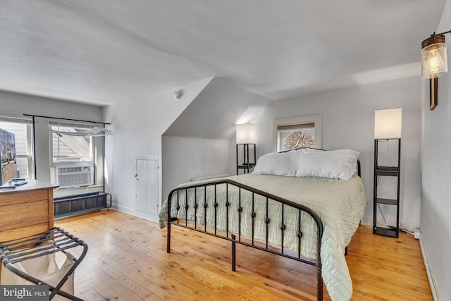 bedroom with wood-type flooring, baseboards, and cooling unit