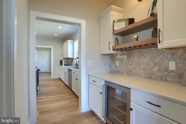 kitchen featuring wine cooler, white cabinetry, and stainless steel dishwasher