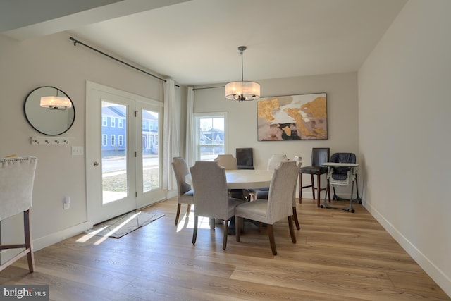 dining space featuring light wood-type flooring and baseboards