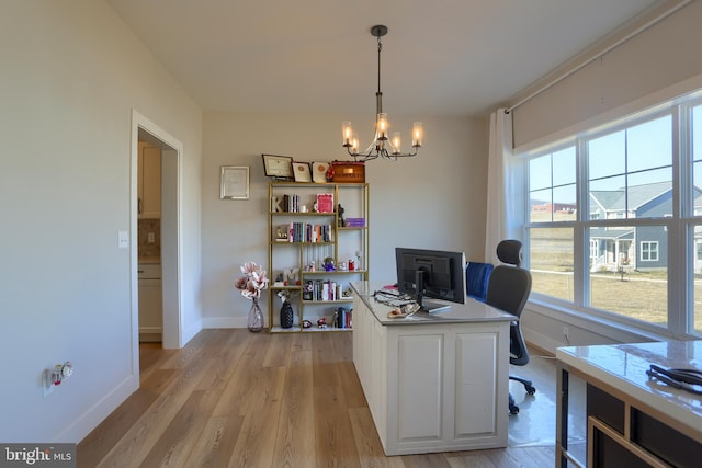 office featuring baseboards, light wood finished floors, and a notable chandelier