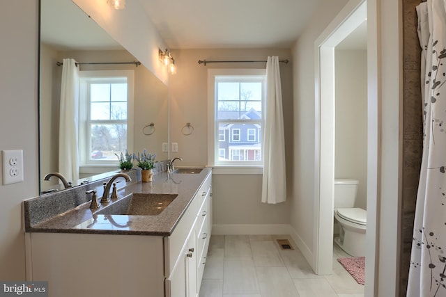 full bath with toilet, baseboards, visible vents, and a sink