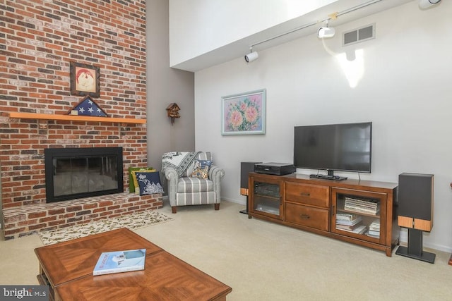 living area featuring visible vents, baseboards, carpet floors, a fireplace, and a high ceiling