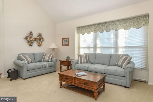 carpeted living room featuring baseboards and vaulted ceiling