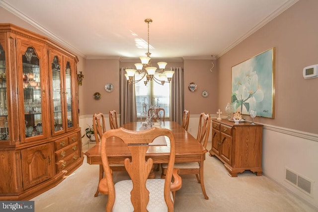 dining space with crown molding, light colored carpet, visible vents, and a chandelier